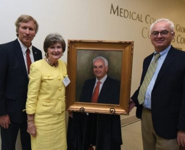 Dean David Hess, artist Sandra T. Colquitt and Dr. Peter F. Buckley, MCG’s 26th dean, unveil Buckley’s portrait at Alumni Weekend.