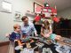 Charlotte, Wes and Bella Kisting role-play with a homemade Dungeons & Dragons game table, as Optimus Prime looks on.