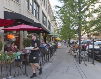 ASHEVILLE, NORTH CAROLINA - JUNE 29, 2017: A busy downtown Asheville street lined with cafes, restaurants, benches and tourists on a summer afternoon