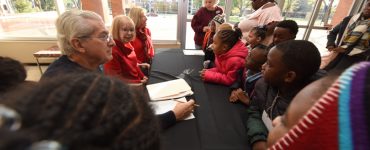 Dr. Paulette Harris, center, welcomes young audience members to Holly and the Snowman in December 2018.