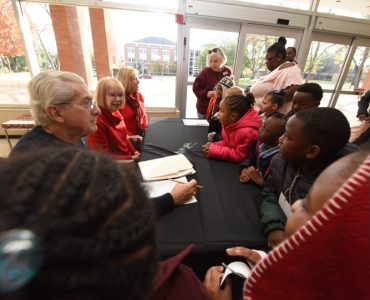 Dr. Paulette Harris, center, welcomes young audience members to Holly and the Snowman in December 2018.