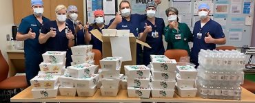 masked medical staff receiving food donation