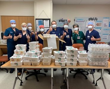masked medical staff receiving food donation