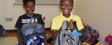 kids smiling with backpacks