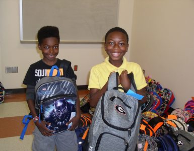 kids smiling with backpacks
