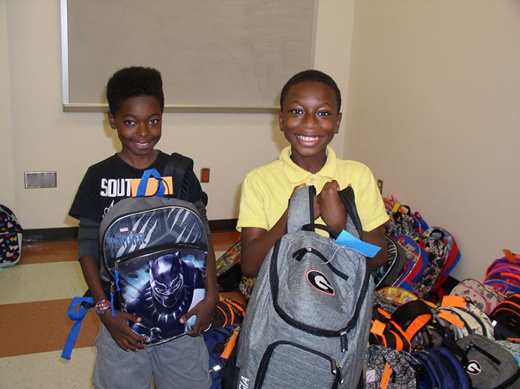 kids smiling with backpacks
