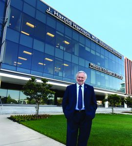 man smiling in front of building