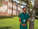 man smiling in front of building