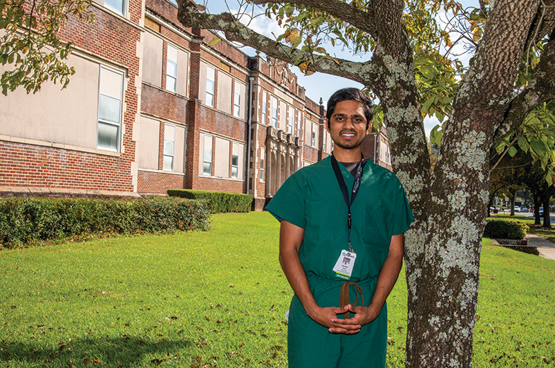 man smiling in front of building