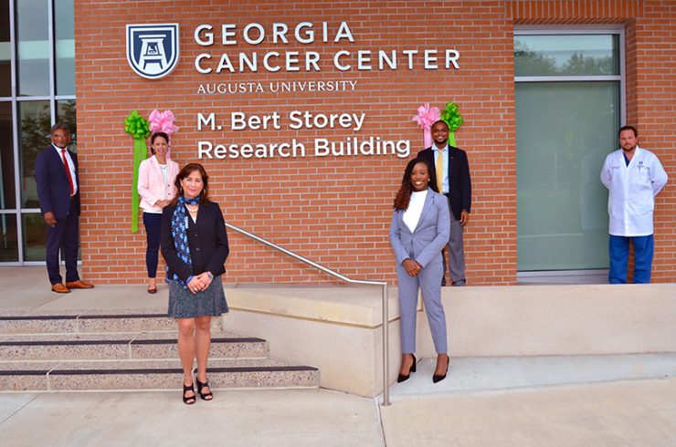 group smiling in front of building