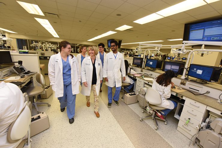 Dentist and students walking in lab