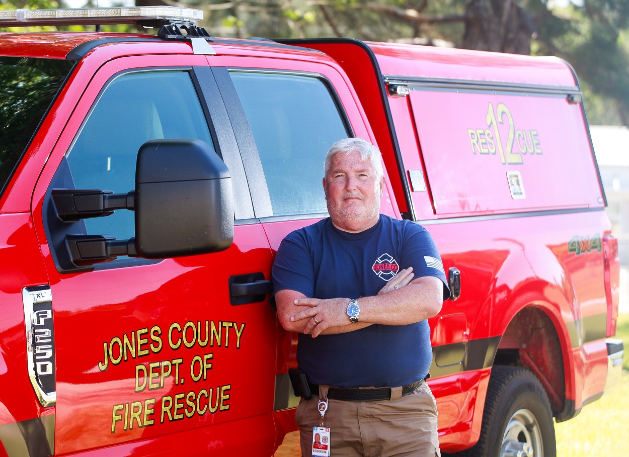 man posing for camera leaning on fire rescue vehicle