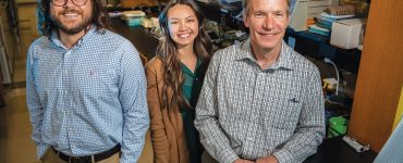 three people standing in a lab smiling