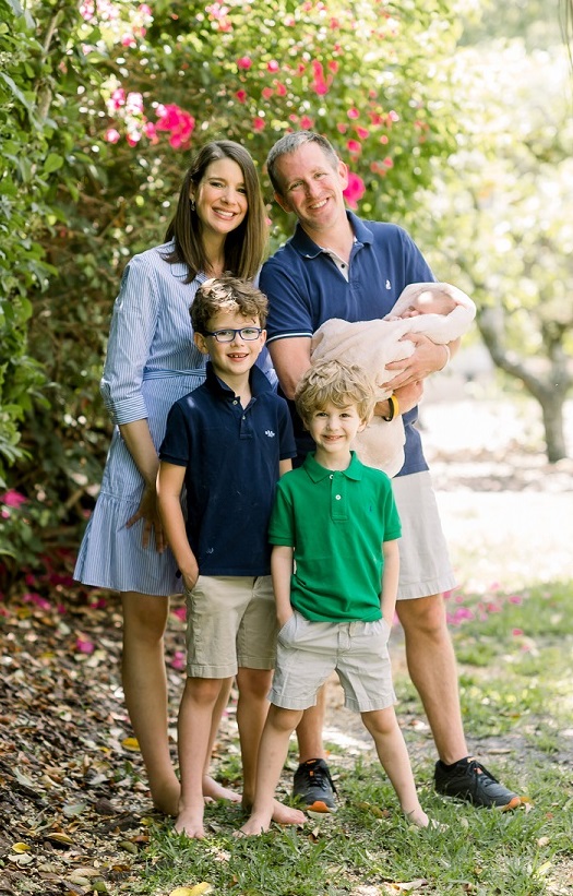 smiling man and woman, two smiling boys and baby