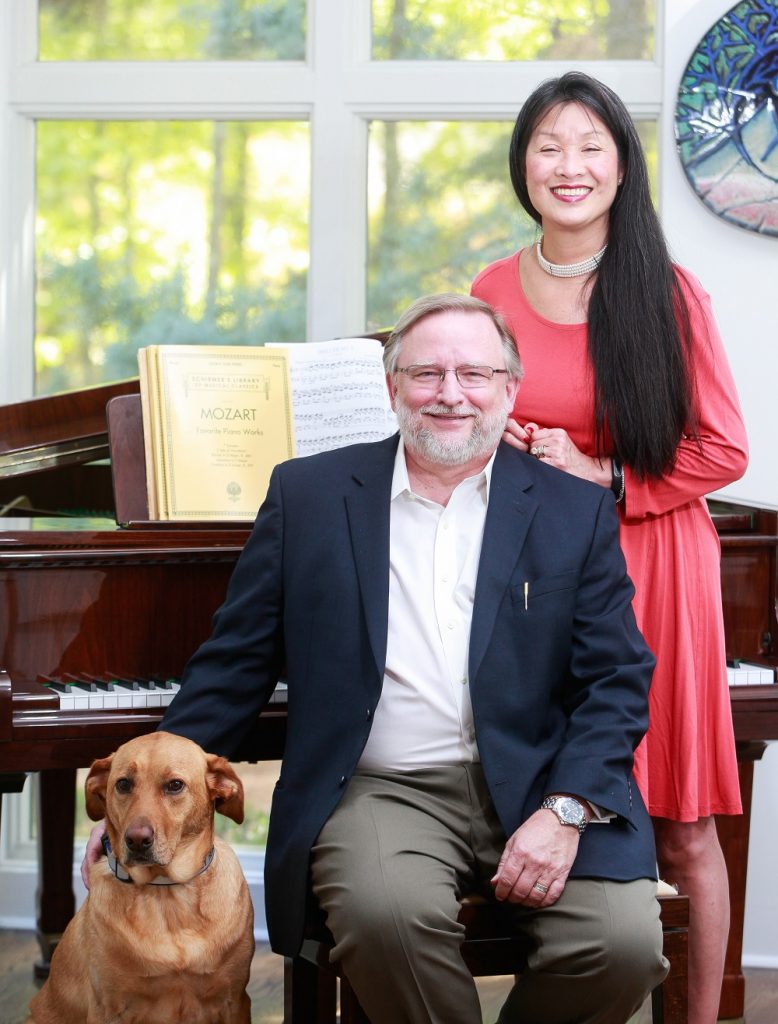 smiling man, smiling woman and dog pose for picture