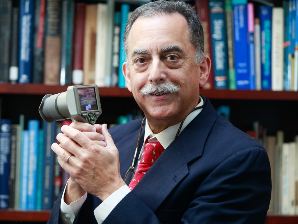 man smiling with pupillometer