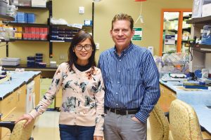 Man and woman standing in lab smiling