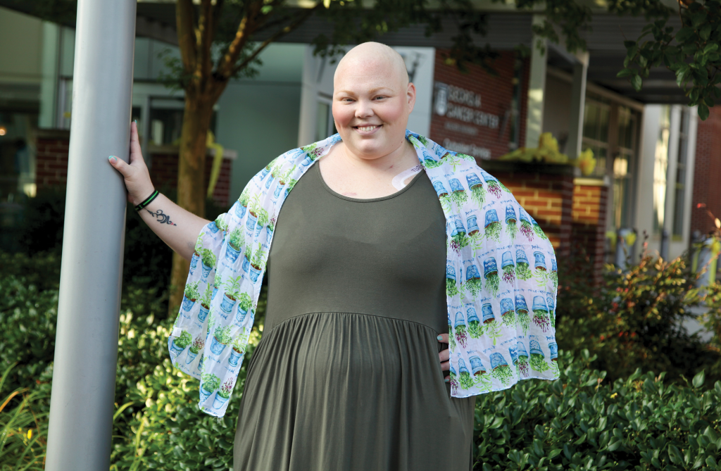 Woman stands smiling at camera