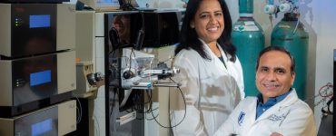 scientists pose in lab for camera