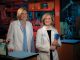 two female scientists smile into camera