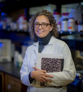 woman scientist smiles into camera