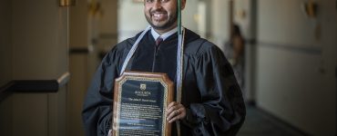 Man holds up award for camera