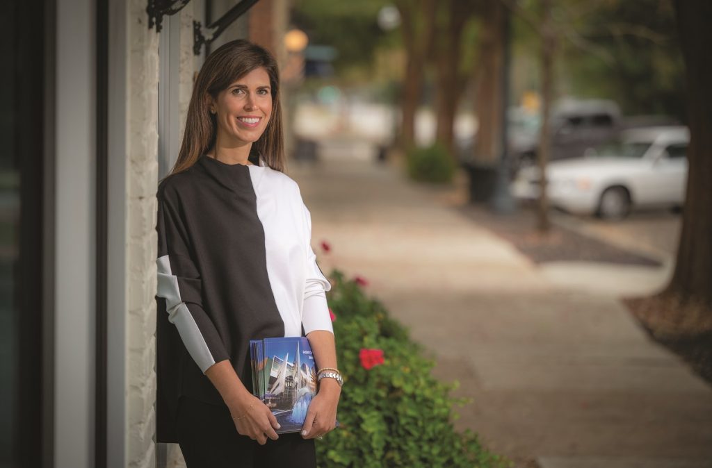 Woman stands outside and smiles for camera