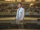 Man stands in front of his class and smiles for camera