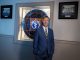 Dr. David Hess stands in front of the MCG stained glass window in the Kelly Building.